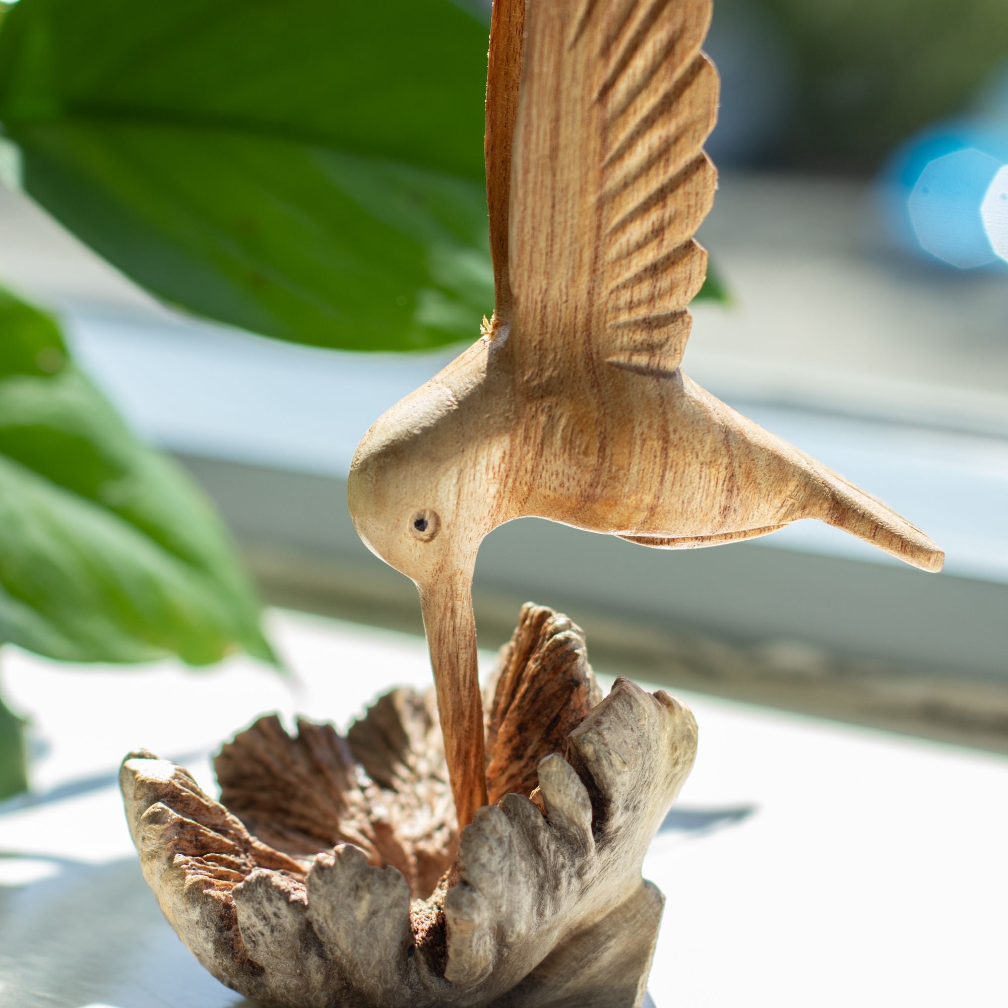 Handgefertigte Skulptur eines Kolibris, der Nektar aus einer Baumverwachsung trinkt